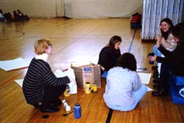 Students being assisted with posters